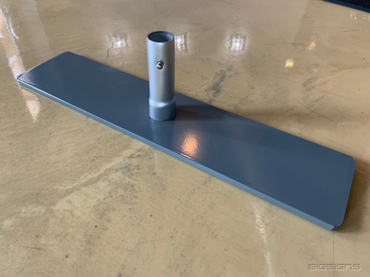 Close-up of a steel barricade base plate with an upright pole socket