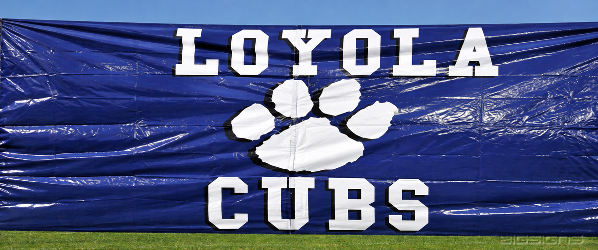 Loyola Cubs breakaway banner with a large paw print held taut above the grass