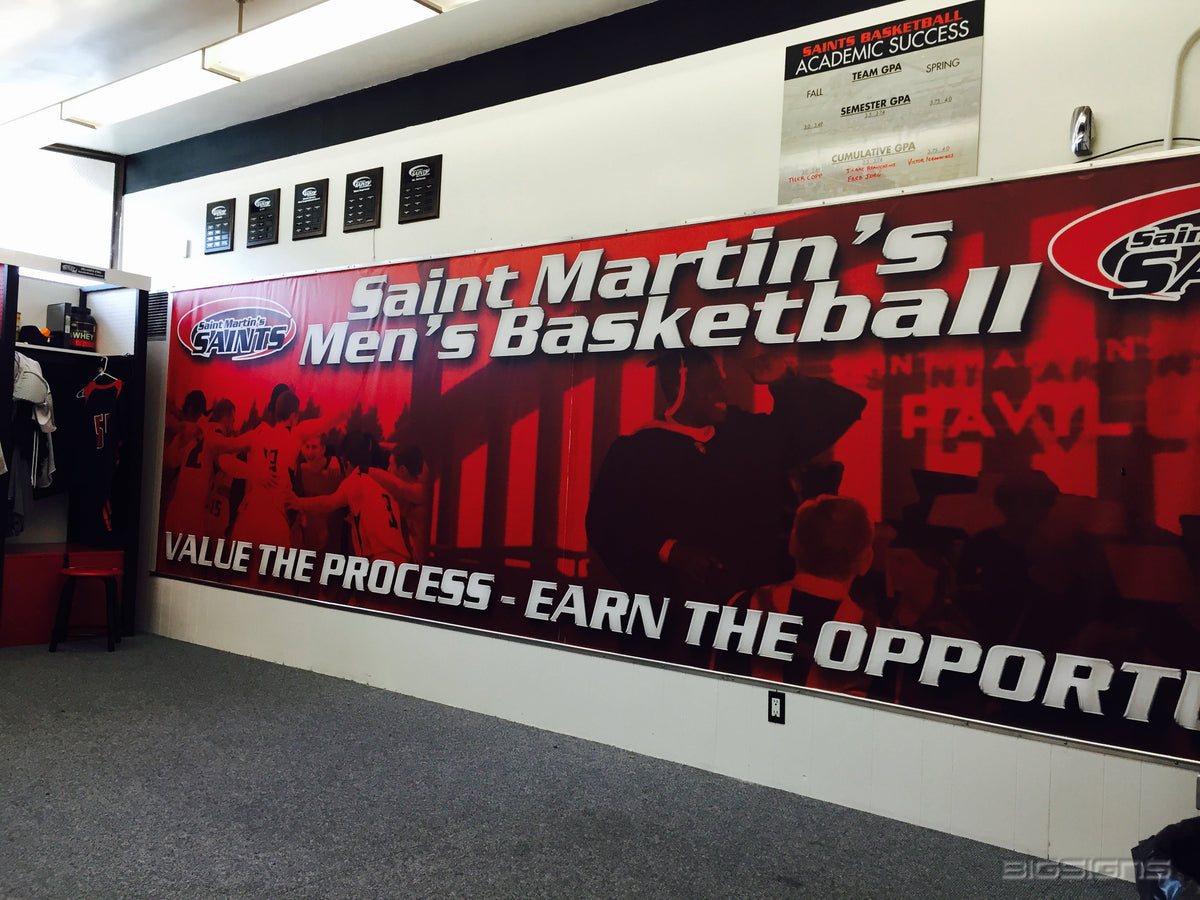 Red Saint Martin's Men's Basketball banner along a locker room wall