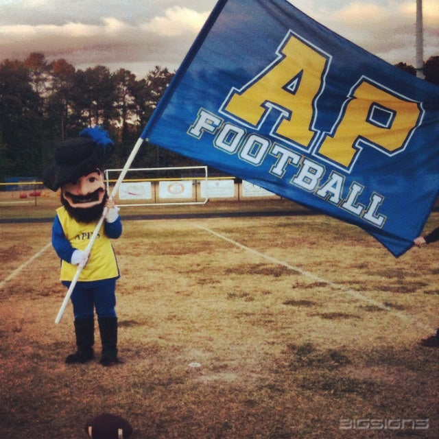 Mascot holding a blue AP Football flag with gold letters on a football field
