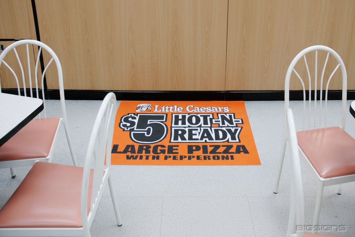 Orange Little Caesars $5 Hot-N-Ready floor mat between dining chairs