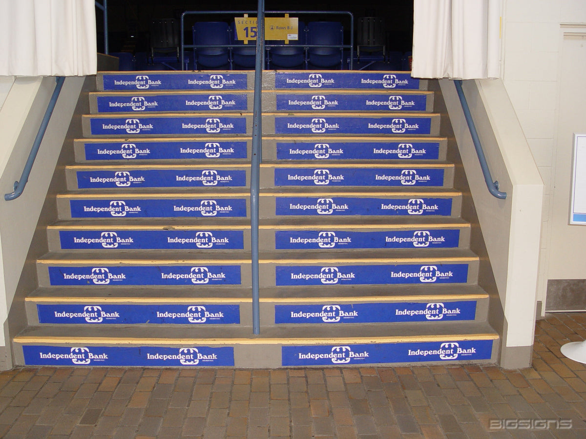 Blue bank logo step signs on every riser of a wide arena staircase