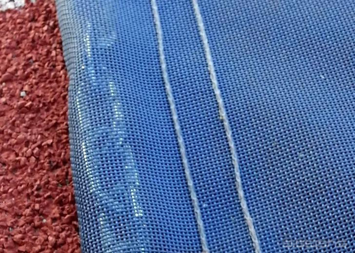 Close-up of GatorMesh with rows of stitching resting on a running track surface