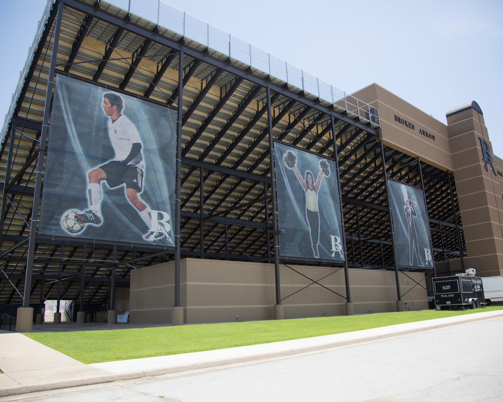 Durable athletic windscreens and fence screens with team imagery on stadium bleachers by BigSigns.