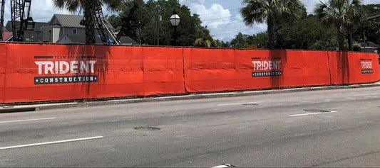 Branded construction fence screen on roadside site, showcasing durable sustainable materials for long-term use