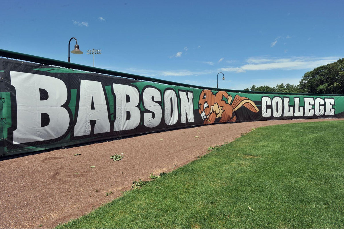 Softball field fence screen displaying college branding, highlighting softball fence screen maintenance for durability