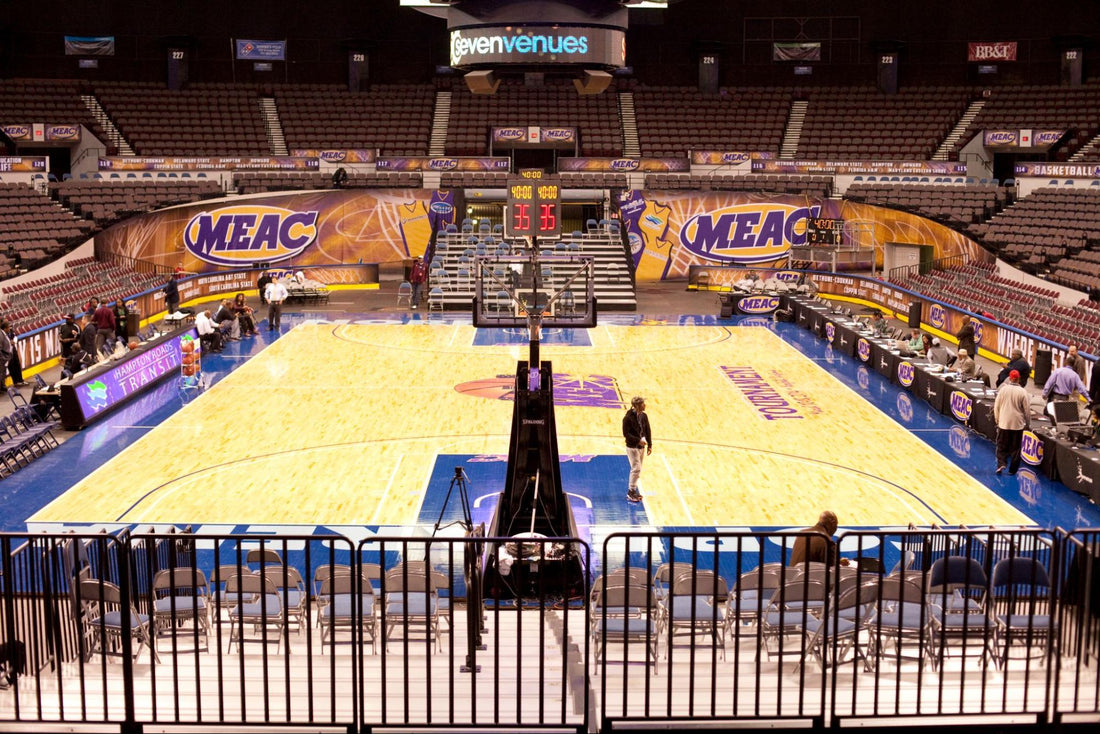 Stadium basketball court with vibrant MEAC graphics and wide event banners covering the arena walls.
