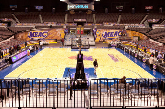 Stadium basketball court with vibrant MEAC graphics and wide event banners covering the arena walls.
