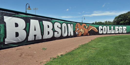 Custom Babson College windscreen displaying school name and mascot on a durable fence screen at the athletic field.