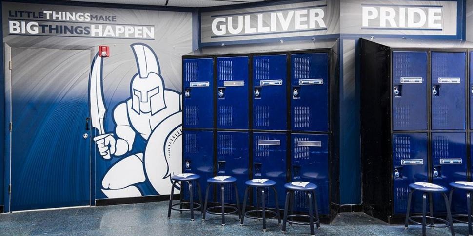 Locker room graphics and wall wraps at Gulliver School featuring mascot and doors branded for school pride.