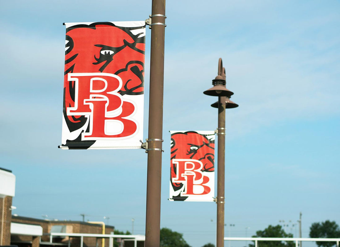 School pole banners with mascot logo mounted on street light poles showing standard pole banner sizes for campus branding