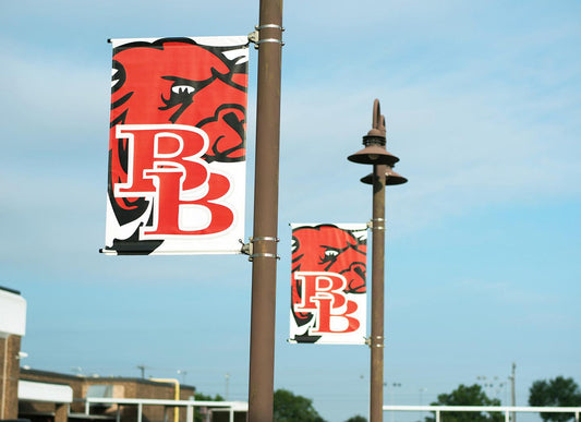 School pole banners with mascot logo mounted on street light poles showing standard pole banner sizes for campus branding
