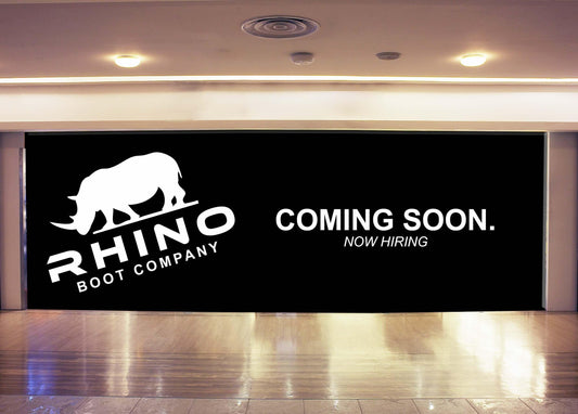 Retail construction barricade wall printed with a Coming Soon and Now Hiring message for Rhino Boot Company storefront