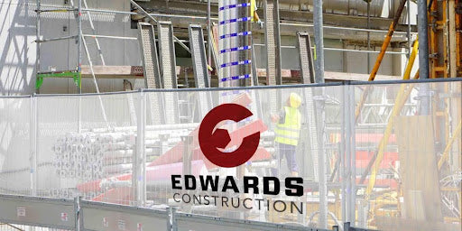 Mesh construction site signage with company logo and name, showcasing branded construction banners for developer visibility.