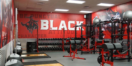 Custom weight room graphics and wall wraps energizing a gym space with motivational visuals and team branding.