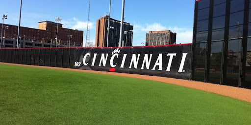 Custom softball windscreen on Cincinnati college field showcasing team branding and enhancing outfield wind control.