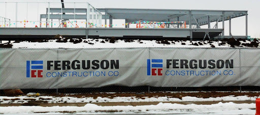 Branded construction fence screen at an active job site showing company logo and name, highlighting the benefits of custom fence screens for construction branding
