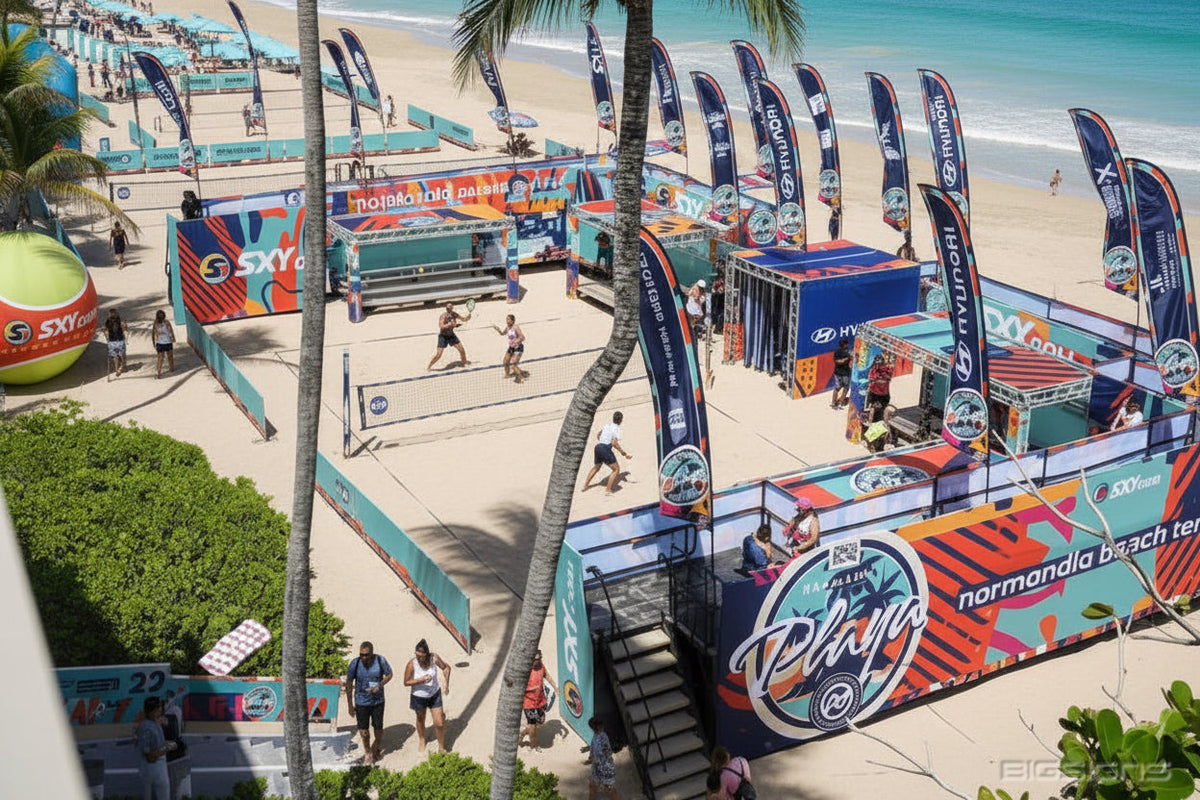 Beach volleyball venue lined with EventFab™ fabric mesh banners and feather flags