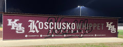 Softball field scene at Kosciusko showcasing branded fence screen and athletic signage backdrop for stadium venue branding.
