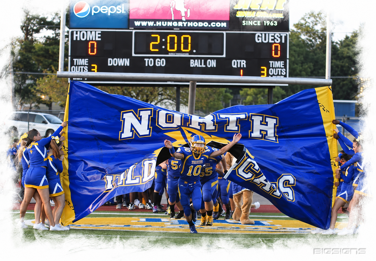 North breakaway banner as the football team runs through between cheerleaders