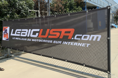 LeBigUSA.com motocross fabric mesh banner on a chain-link fence