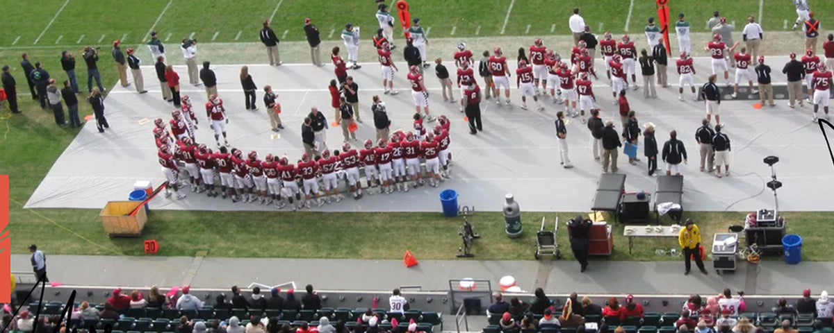 Football team gathered on a gray SidelineShield™ cover protecting the sideline turf