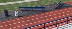 Track protector beneath a sideline bench and water jugs on a red running track