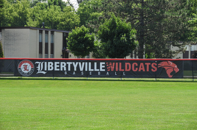 Custom baseball windscreen featuring bold graphics installed on stadium fences at athletic fields and sports facilities.