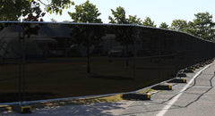 Extreme screen windscreen attached to fencing along grassy field, showing robust privacy and weather-resistant mesh.