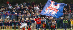 Navy and red M logo RunnerFlag™ carried along the sideline in front of a football crowd