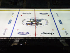 Center ice logos and sponsor graphics installed on a hockey rink featuring Grand Rapids branding and premium ad placement.