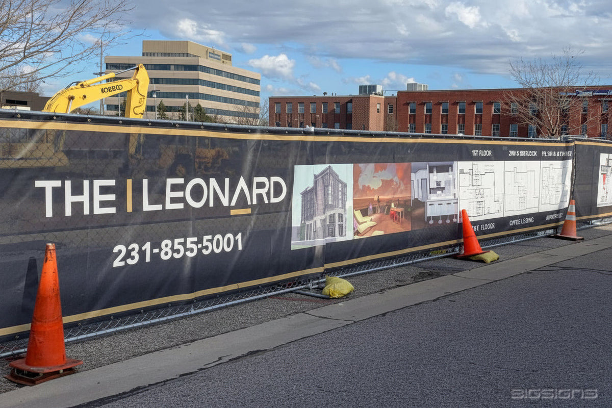 The Leonard vinyl mesh branding screen with renderings and phone on a jobsite fence