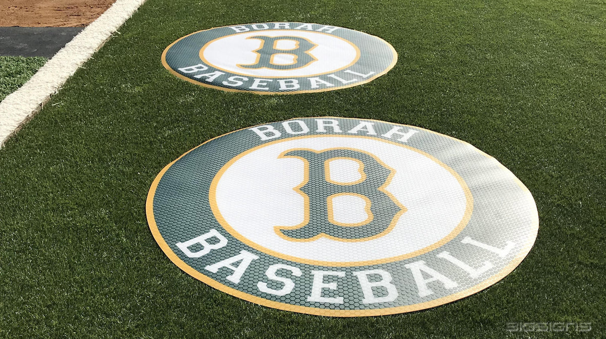 Two gray and white Borah Baseball B logo on-deck circles on green turf