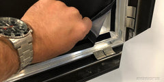Hand opening the hinged aluminum frame to peel out a fabric graphic