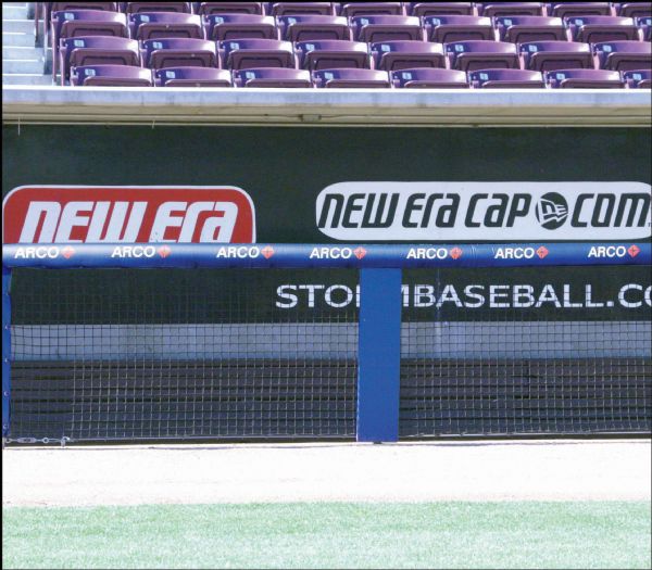 Football goal post padding with custom team branding & bright colors installed on field for safety & enhanced stadium visuals.